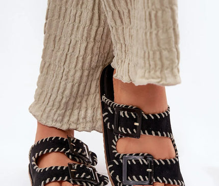 Sandales bohème-chic inspirées de l'artisanat brésilien avec coutures décoratives blanches, boucles noires et semelle confortable, parfaites pour un style décontracté et élégant, évoquant l'énergie des plages de Rio et le charme des marchés artisanaux.