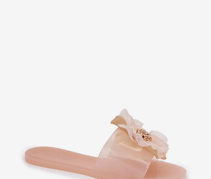 Sandales glamour d'inspiration brésilienne, de couleur rose pâle, ornées d'une fleur exotique luxueuse sur la bride transparente. Idéales pour un style estival et élégant, parfaites pour les promenades sous le soleil ou les soirées en bord de mer.