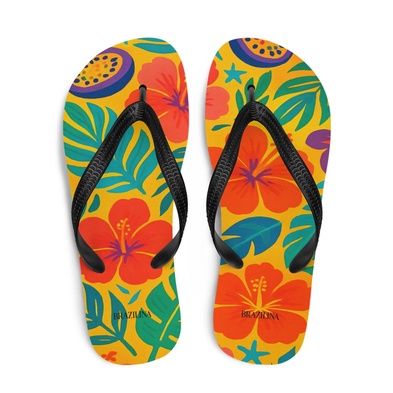Tongs brésiliennes colorées avec motifs tropicaux de fleurs exotiques rouges et feuilles vertes sur fond jaune, évoquant la nature et la forêt tropicale du Brésil. Idéales pour un style décontracté et festif, parfaites pour la plage ou les jours ensoleillés.