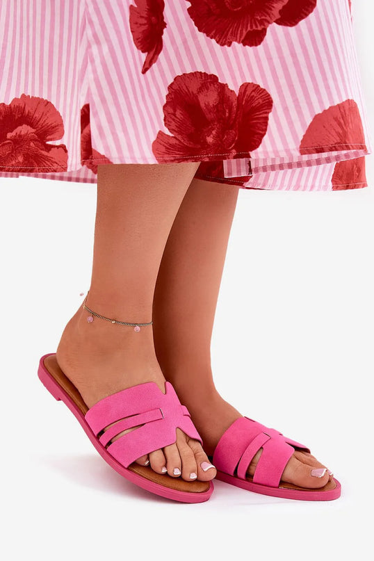 Claquettes classiques pour femmes en suédine, de couleur rose, montées sur un talon plat de 1 cm. Dotées de découpes modernes et d'une petite bride subtile. Portées avec une robe à rayures roses et rouges, parfaites pour un look estival élégant et confortable.