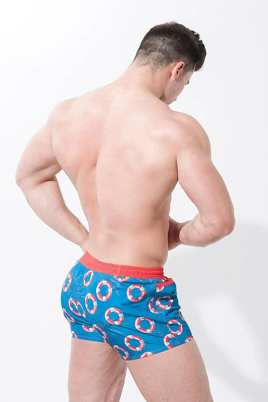 Short de bain homme inspiré des plages brésiliennes, motif bouées de sauvetage rouge et blanc sur fond bleu, ceinture rouge pour un style tropical et décontracté, parfait pour les journées ensoleillées et les vacances.