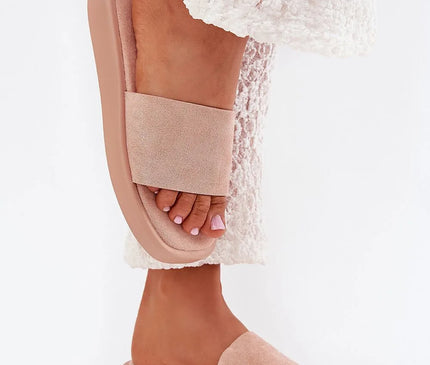 Claquettes classiques pour femmes en suédine écologique, de couleur rose pâle, montées sur une plateforme de 2,5 cm. Alliant confort et style simple, ces sandales sont parfaites pour des looks décontractés et se portent avec des robes, jupes ou pantalons. Matière principale et semelle plantaire en cuir suédé écologique. Vue portée sur un pied, avec une tenue en dentelle blanche.