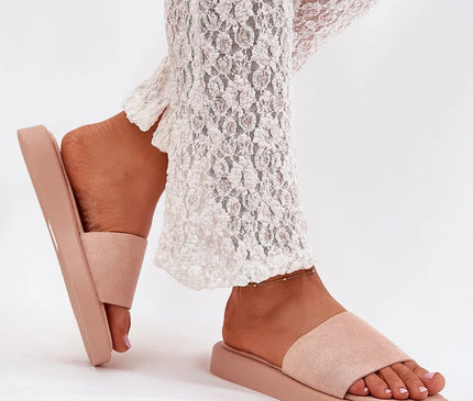 Claquettes classiques pour femmes en suédine écologique rose pâle avec plateforme de 2,5 cm, portées avec un pantalon en dentelle blanche. Alliant confort et style, elles s'accordent parfaitement avec des tenues décontractées comme des robes, jupes ou pantalons.