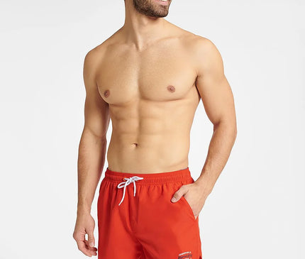 Homme portant un short de bain rouge GUILD à séchage rapide, avec une taille élastique réglable et des détails contrastés. Modèle confortable et tendance, idéal pour la plage et les activités aquatiques. Disponible en tailles M, L, XL, XXL.