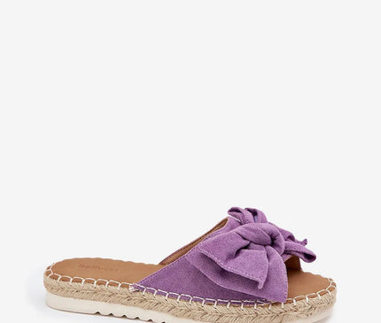 Sandales violettes avec un nœud en tissu inspirées de l'artisanat brésilien, dotées d'une semelle tressée évoquant les espadrilles traditionnelles typiques des plages et marchés du Brésil. Idéales pour un style tropical et estival alliant confort et élégance.