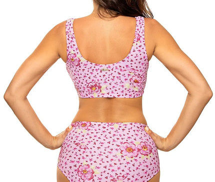 Maillot de bain deux pièces rose à motif floral, style sportif, composé d'un haut élastique sans baleines à dos couvrant et d'un slip taille haute, fabriqué en tissu italien Carvico Tessuti, mettant en valeur le bronzage.