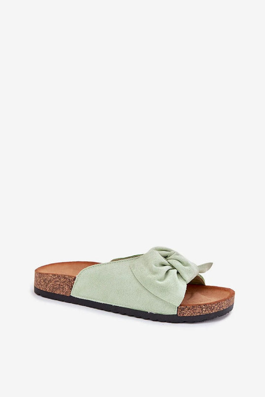 Sandales inspirées du style brésilien avec une semelle en liège, un nœud décoratif sur la bride en tissu vert pastel, évoquant un design tropical et décontracté, parfaites pour la plage ou une soirée élégante.