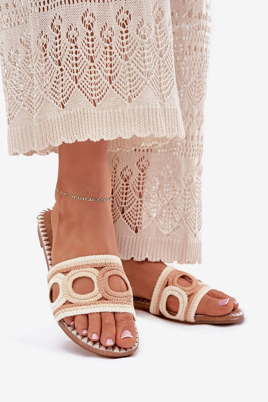 Sandales inspirées de l'artisanat brésilien avec détails tissés, design élégant et bohème, parfaites pour l'été et associées à une robe crochetée ajourée blanche, évoquant les plages de Bahia et l'esprit décontracté du Brésil.