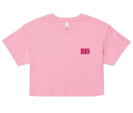 Crop top rose avec l'inscription 'Rio' en lettres rouges, inspiré par l'énergie et la culture brésilienne. Idéal pour un style décontracté, ce vêtement évoque les ambiances festives de Rio de Janeiro et le chic contemporain sous le soleil brésilien.