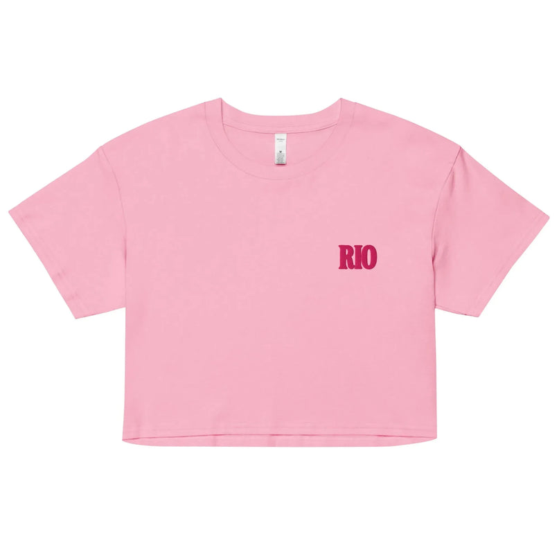 Crop top rose avec l'inscription 'Rio' en lettres rouges, inspiré par l'énergie et la culture brésilienne. Idéal pour un style décontracté, ce vêtement évoque les ambiances festives de Rio de Janeiro et le chic contemporain sous le soleil brésilien.