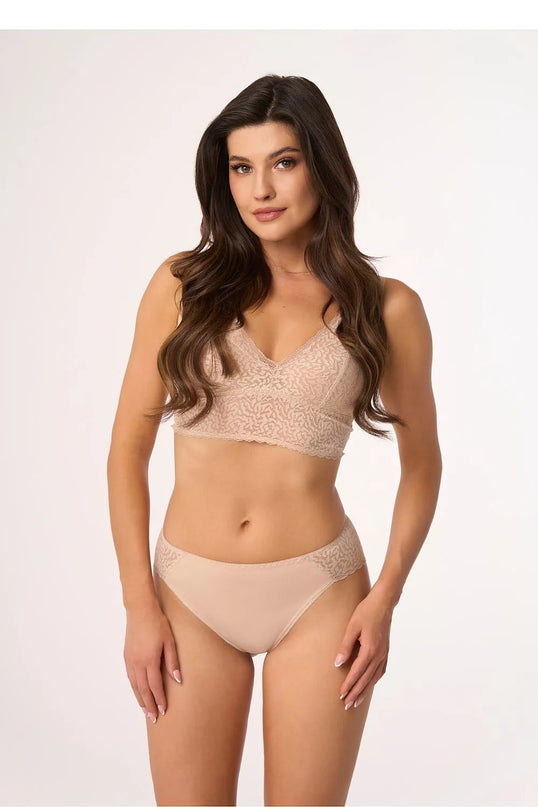 Sous-vêtements inspirés du style brésilien en dentelle délicate, mettant en valeur la sensualité et l'élégance naturelle, portés par un mannequin. Ensemble beige composé d'un soutien-gorge sans armatures et d'une culotte ornée de détails subtils.