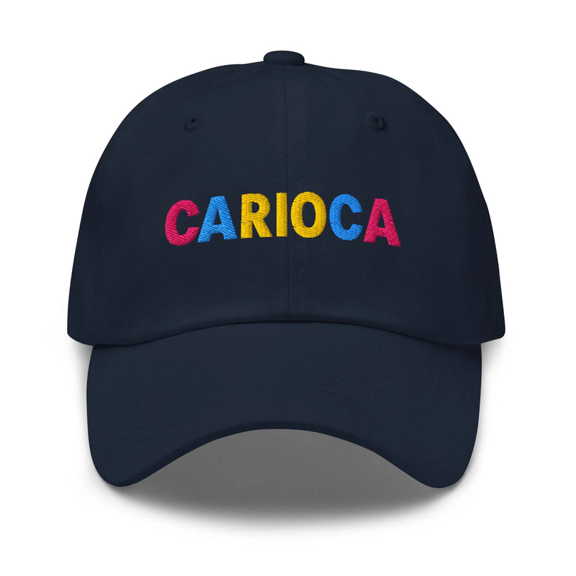 Casquette bleu marine avec le mot 'Carioca' brodé en lettres colorées (rose, jaune et bleu) sur le devant. Accessoire inspiré par la culture vibrante de Rio de Janeiro, mettant en avant l'esprit festif et chaleureux du Brésil. Parfaite pour un style décontracté et contemporain célébrant la richesse culturelle carioca.