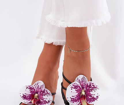 Sandales élégantes ornées d'orchidées tropicales violettes et blanches, inspirées de la flore luxuriante du Brésil, parfaites pour les plages et les festivals comme le Carnaval.