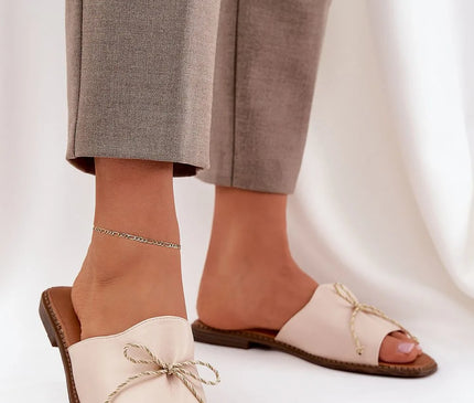 Sandales élégantes d'inspiration brésilienne en cuir beige avec un cordon noué raffiné, évoquant la sophistication et la légèreté des plages tropicales. Idéal pour un style décontracté et ensoleillé, parfait pour les longues journées ou les soirées animées.