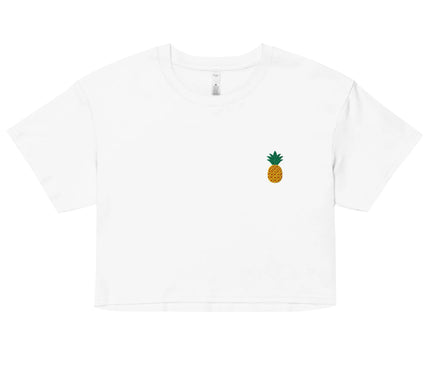 Crop top blanc minimaliste avec un petit emblème d'ananas, symbole tropical évoquant l'énergie solaire et la convivialité du Brésil. Design inspiré de la nature, parfait pour un style décontracté et une ambiance estivale.