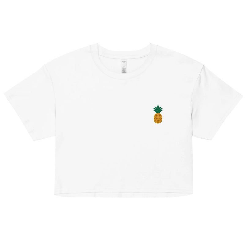Crop top blanc minimaliste avec un petit emblème d'ananas, symbole tropical évoquant l'énergie solaire et la convivialité du Brésil. Design inspiré de la nature, parfait pour un style décontracté et une ambiance estivale.