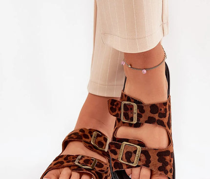 Claquettes élégantes en suédine écologique avec imprimé léopard, montées sur plateforme de 3.5 cm pour allier confort et style. Les brides ajustables avec boucles métalliques et la semelle profilée garantissent un confort optimal pour l'été, s'accordant parfaitement aux robes ou pantalons.