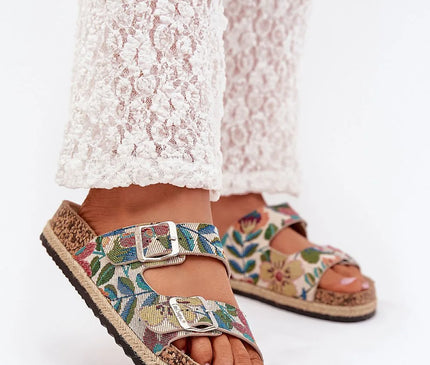 Sandales pour femmes de la marque Lee Cooper avec plateforme en liège tressé, deux brides réglables à motifs floraux colorés, boucles argentées à l'avant et semelle profilée pour un confort optimal, portées avec un pantalon blanc en dentelle, idéale pour les journées estivales.