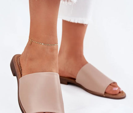 Sandales minimalistes brésiliennes en cuir beige, design épuré et ouvert, adaptées pour un confort estival. Associées à une tenue décontractée et élégante, idéales pour les balades en bord de mer ou en ville.
