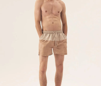 Short de bain homme beige inspiré du style brésilien, évoquant les plages tropicales et la nature luxuriante, avec une coupe décontractée et élégante. Parfait pour les journées en bord de mer, conçu avec des motifs subtils qui rendent hommage à la culture festive et ensoleillée du Brésil.