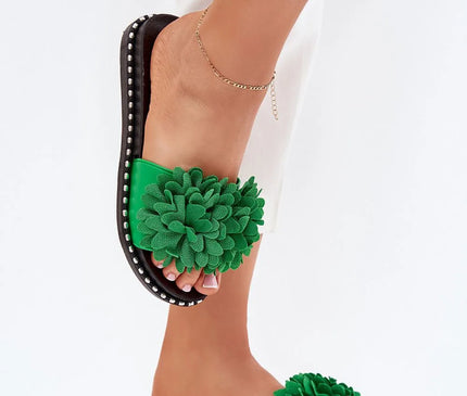 Mules pour femmes avec décoration florale verte spectaculaire sur le devant, semelle en caoutchouc noir ornée de petits clous décoratifs autour. Parfaites pour l'été, avec une hauteur de semelle de 2,5 cm, assorties à une tenue blanche élégante.