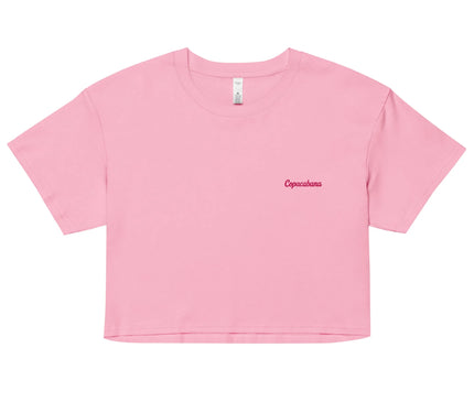 Crop top rose minimaliste pour femme, avec le texte 'Copacabana' brodé en rouge sur la poitrine. Inspiré du style brésilien, ce vêtement évoque la plage emblématique de Rio de Janeiro et le style de vie chaleureux et décontracté du Brésil. Idéal pour une tenue estivale et tendance.