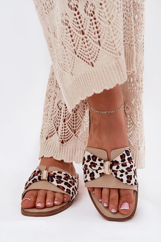 Claquettes classiques pour femmes à talon plat en cuir artificiel, ornées d'un nœud décoratif imprimé animalier à l'avant. Sandales beige stylées et confortables, idéales pour les tenues d'été comme les robes, jupes ou shorts. Hauteur de talon : 1 cm.