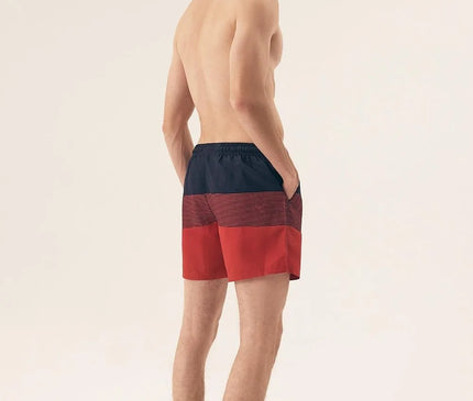 Short de bain pour homme en polyester 100 % à imprimé moderne rouge et noir, avec une coupe ajustée et des poches latérales. Matière légère à séchage rapide, idéal pour la plage, la piscine ou les vacances. Présenté porté de dos pour illustrer le style et la coupe confortable.