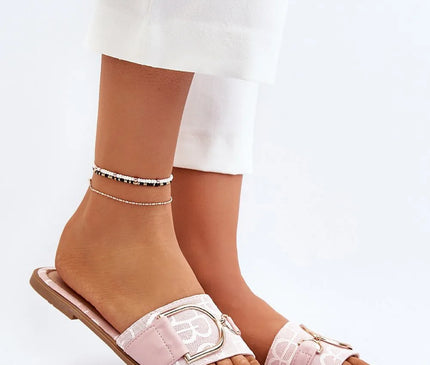 Sandales plates élégantes en tissu rose pastel avec boucle dorée, inspirées du style brésilien décontracté et sophistiqué. Idéales pour un look chic et tropical, parfaites pour les plages ou les soirées estivales. Portées avec un pantalon blanc et ornées de bracelets de cheville minimalistes.