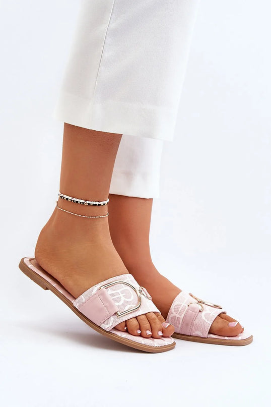 Sandales plates élégantes en tissu rose pastel avec boucle dorée, inspirées du style brésilien décontracté et sophistiqué. Idéales pour un look chic et tropical, parfaites pour les plages ou les soirées estivales. Portées avec un pantalon blanc et ornées de bracelets de cheville minimalistes.