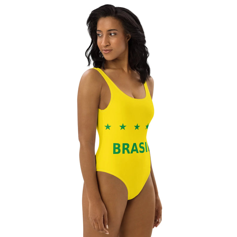 Maillot de bain une pièce jaune inspiré du Brésil, orné du mot 'Brasil' et de petites étoiles vertes, évoquant la joie et l'énergie des plages brésiliennes, porté par une femme élégante.