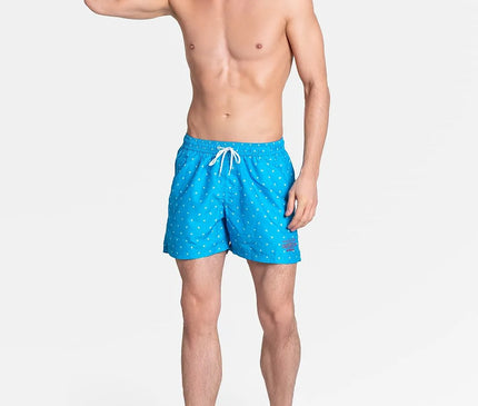 Short de bain ample et doublé pour homme, couleur bleue avec un motif discret, équipé d'une ceinture élastique ajustable avec cordon de serrage, tissu à séchage rapide, présenté par un mannequin, collection été 2021 Henderson.