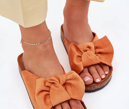 Sandales inspirées du Brésil en daim orange avec un nœud décoratif, représentant un style élégant et décontracté, parfaites pour les tenues estivales ou les promenades sur la plage. Semelle en liège offrant confort et allure tendance, conçue avec soin pour allier esthétique et fonctionnalité.
