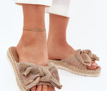 Sandales décontractées et élégantes inspirées de la mode brésilienne, confectionnées avec des matériaux naturels tressés, caractérisées par un nœud décoratif et une semelle en corde, idéales pour un style estival, festif et authentique.