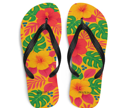 Tongs colorées avec motifs tropicaux inspirés de la flore brésilienne, incluant fleurs d'hibiscus rouges et jaunes, feuilles luxuriantes vertes, et détails bleus. Design évoquant l'énergie festive des plages du Brésil, parfait pour un look estival exotique.