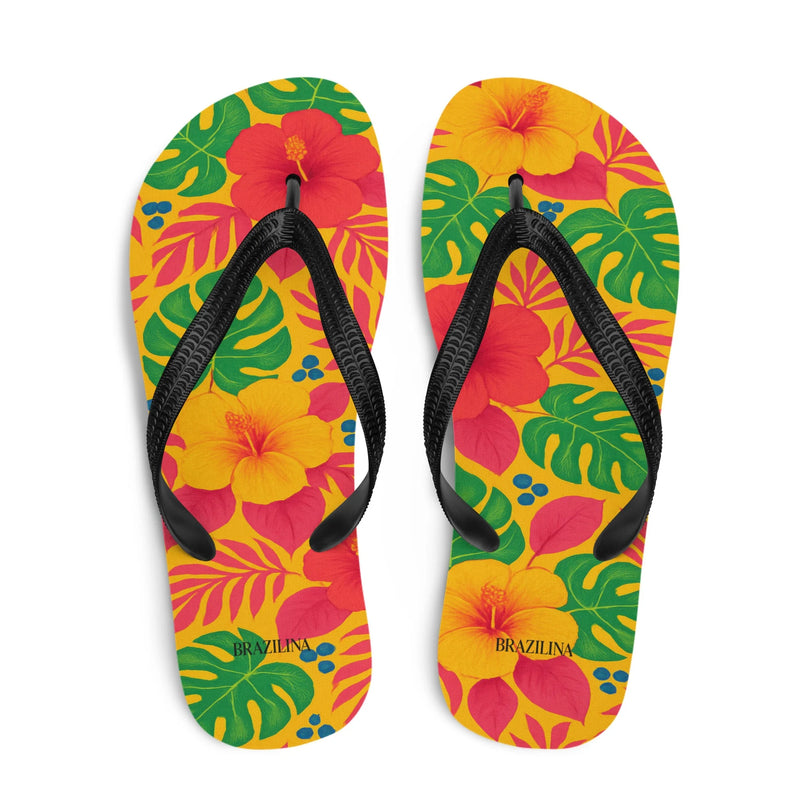 Tongs colorées avec motifs tropicaux inspirés de la flore brésilienne, incluant fleurs d'hibiscus rouges et jaunes, feuilles luxuriantes vertes, et détails bleus. Design évoquant l'énergie festive des plages du Brésil, parfait pour un look estival exotique.