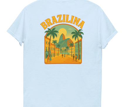 T-shirt blanc avec un design vibrant inspiré du Brésil, illustrant une rue bordée de palmiers avec des bâtiments colorés, une vue sur le Pain de Sucre, et un coucher de soleil tropical. Le mot 'Brazilina' est inscrit en haut dans une typographie jaune-orange rappelant l'énergie ensoleillée et festive du pays.