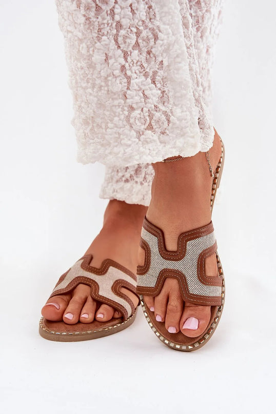 Sabots pour femmes en tissu et cuir écologique, avec une décoration dorée sur la semelle. Ce modèle à talon plat de 1,5 cm est parfait pour des tenues décontractées et estivales, offrant un confort quotidien grâce à sa semelle intérieure souple.