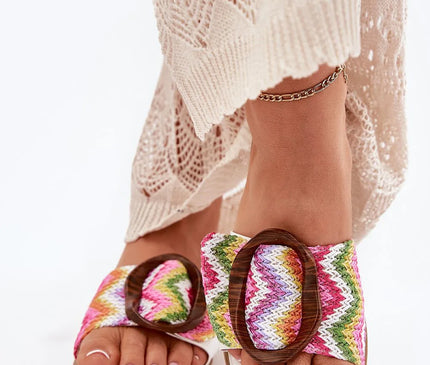 Sandales artisanales brésiliennes colorées pour femme avec motif tissé à chevrons multicolores, boucle en bois décorative, portées avec une robe en crochet beige – chaussures inspirées du style de vie décontracté et tropical du Brésil, parfaites pour un look plage ou urbain.