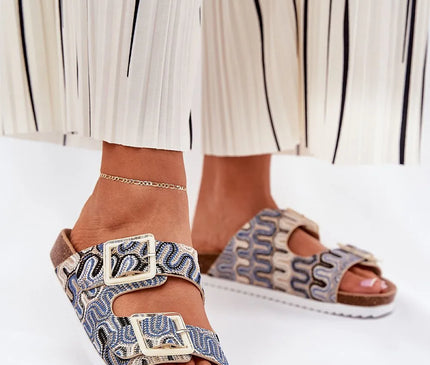 Sandales élégantes inspirées des traditions artisanales brésiliennes avec motifs tissés rappelant le tissage ancestral, dotées de boucles dorées. Elles incarnent l'esprit des plages tropicales et offrent un style exotique et confortable.