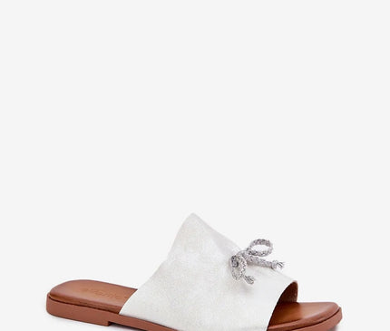 Sandales minimalistes et élégantes inspirées du style brésilien avec une bride blanche ornée d'un nœud artisanal, semelle marron, parfaites pour un look décontracté et chic alliant confort et esthétique, idéales pour un usage quotidien ou une balade en bord de mer.