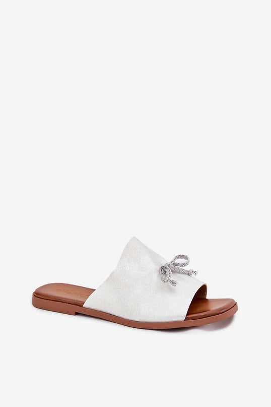 Sandales minimalistes et élégantes inspirées du style brésilien avec une bride blanche ornée d'un nœud artisanal, semelle marron, parfaites pour un look décontracté et chic alliant confort et esthétique, idéales pour un usage quotidien ou une balade en bord de mer.