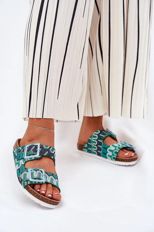 Sandales inspirées du Brésil, avec des motifs ondulés multicolores bleu et vert, dotées de deux boucles ajustables et d'une semelle en liège confortable. Ces sandales incarnent l'esprit brésilien avec leur style artisanal et élégant, parfait pour un look décontracté et raffiné.