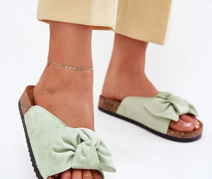 Sandales inspirées du mode de vie brésilien, couleur vert pastel, avec un nœud décoratif en matière douce, semelle en liège confortable, idéales pour une promenade en bord de mer ou une soirée décontractée, évoquant l'élégance et la légèreté tropicales.