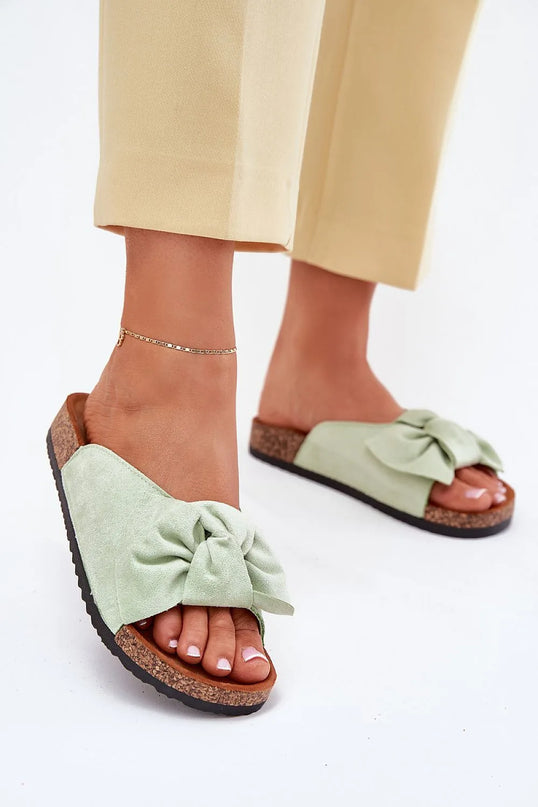 Sandales inspirées du mode de vie brésilien, couleur vert pastel, avec un nœud décoratif en matière douce, semelle en liège confortable, idéales pour une promenade en bord de mer ou une soirée décontractée, évoquant l'élégance et la légèreté tropicales.
