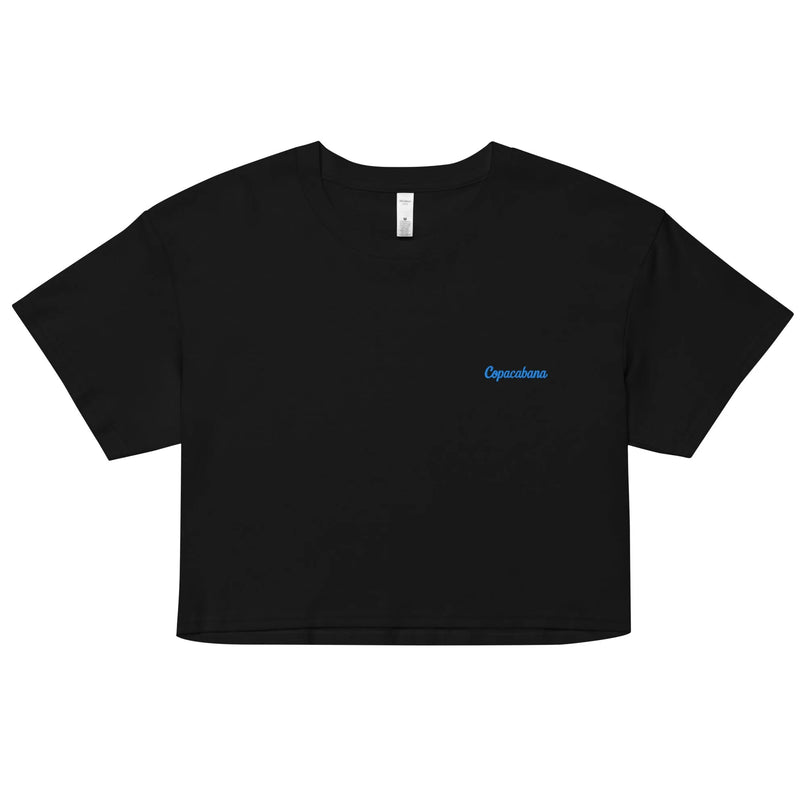 T-shirt court noir avec un design minimaliste, portant l'inscription 'Copacabana' en bleu sur le côté gauche de la poitrine, inspiré de l'essence tropicale et décontractée de la plage de Copacabana, évoquant les couchers de soleil brésiliens et les promenades au bord de l'océan.