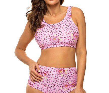 Maillot de bain deux pièces pour femme, style sportif, fabriqué en tissu italien Carvico Tessuti, de couleur rose avec motifs floraux et taille haute. Haut élastique type brassière avec inserts amovibles, mettant en valeur le bronzage. Produit polonais.