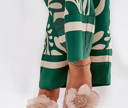 Sandales glamour avec design floral beige inspiré des paysages tropicaux et des fleurs exotiques du Brésil, portées avec une tenue verte à motifs, parfaites pour des occasions estivales et festives.