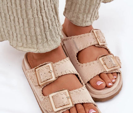 Claquettes pour femmes en suédine écologique beige, ornées de coutures décoratives et de grandes boucles dorées à l'avant. Sandales tendances avec une semelle profilée pour un confort optimal, idéales pour les journées d'été, les voyages et les tenues urbaines.