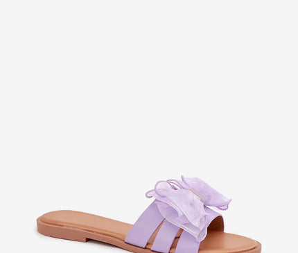 Sandales pour femmes en cuir écologique de couleur lavande avec un nœud en tulle décoratif, montées sur un talon plat de 1 cm, idéales pour les tenues estivales, assorties à des robes, jupes ou pantalons. Taille disponible entre 36 et 41.